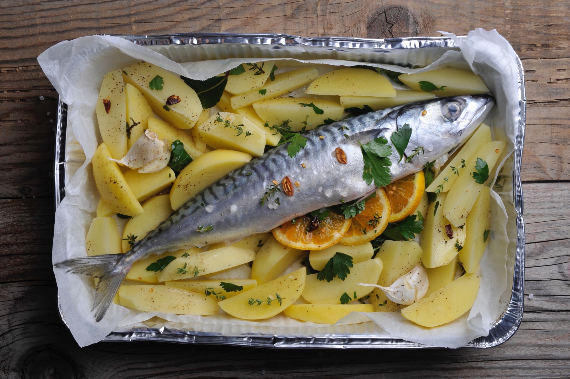 Fresh mackerel stuffed with orange on a bed of potatoes, prepped for oven | recipe and styling: Orsola Ciriello Kogan | photo: ©LuciaZeccara